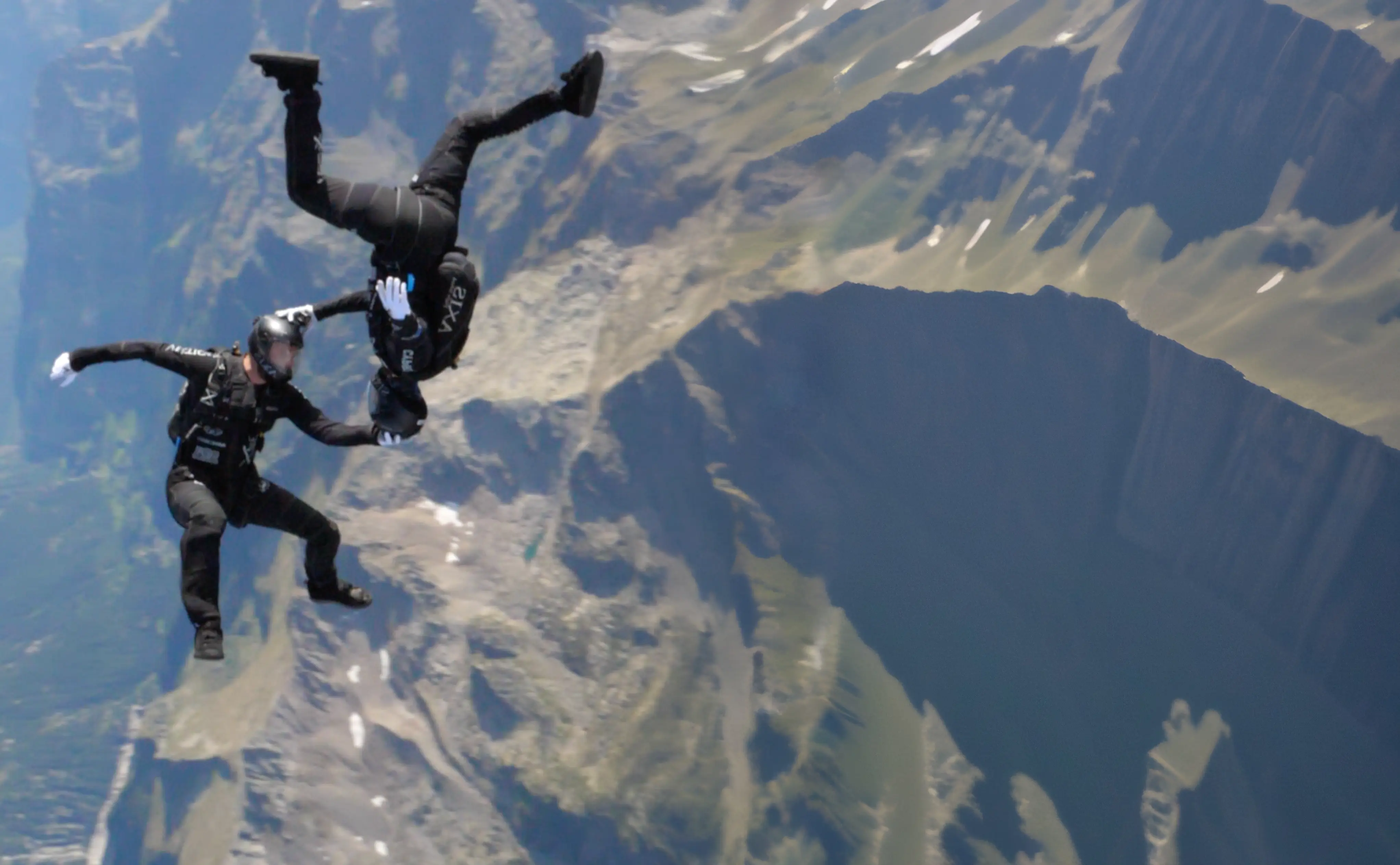 Sport skydivers in freefall over mountains